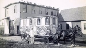 Właściciel T.H.Buckley Lunch Wagon Builder przed siedzibą firmy i wagonem zaprzężonym w konie